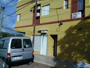 a van parked in front of a yellow building at WINTER Departamentos Temporarios in Formosa