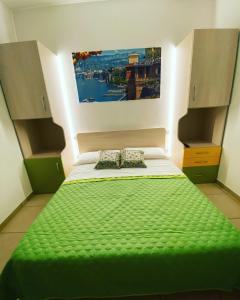 カステッランマーレ・ディ・スタービアにあるIl Vecchio Pozzo Apartamentsのベッドルーム1室(壁に絵画が描かれた緑のベッド1台付)