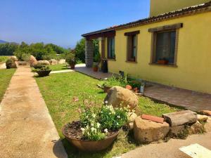 ein Haus mit ein paar Blumen im Hof in der Unterkunft I Carrubi in San Priamo