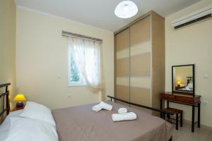 a bedroom with two towels on a bed and a mirror at Vasso Apartments 3 in Kissamos
