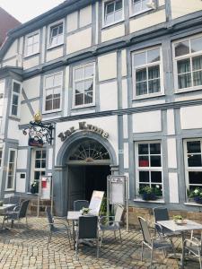 a building with tables and chairs in front of it at Hotel zur Krone in Hameln