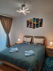 a bedroom with a bed with two towels on it at Sorin`s Comfortable Apartment in Braşov