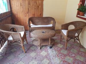 a living room with wicker chairs and a table at Vila Andra in Azuga