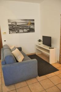 sala de estar con sofá azul y TV en Monolocale - B&B Sarita's Rooms, en Certosa di Pavia