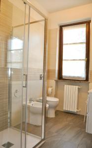 y baño con aseo y ducha acristalada. en Monolocale - B&B Sarita's Rooms, en Certosa di Pavia