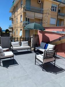 a group of chairs and an umbrella on a patio at La Trabacca, attico nel pieno centro di Levanto in Levanto