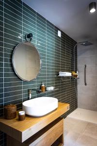 a bathroom with a white sink and a mirror at Hôtel L'Ouvrée in Savigny-lès-Beaune