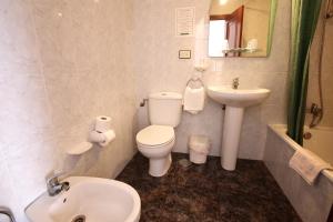 y baño con lavamanos, aseo y lavamanos. en Hostal San Roque, en Portonovo