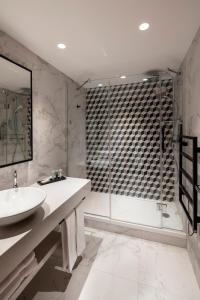 
a bathroom with a sink, toilet and bathtub at Hôtel & Spa Hélianthal by Thalazur in Saint-Jean-de-Luz
