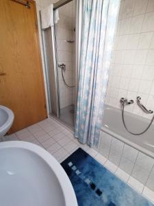 une salle de bain avec une baignoire, des toilettes et une douche dans l'établissement Ferienwohnung zum Wohlfühlen, à Altensteig