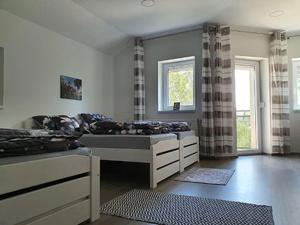 a large bedroom with two beds and two windows at Monostor Panzió in Komárom