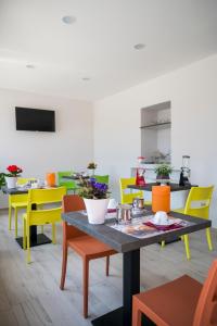 une salle à manger avec des chaises colorées et une table dans l'établissement Vino e Turismo, à San Defedente di Cervasca