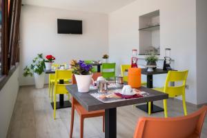 une salle à manger avec des chaises colorées et une table dans l'établissement Vino e Turismo, à San Defedente di Cervasca