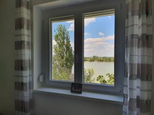 ventana en una habitación con vistas al lago en Monostor Panzió, en Komárom