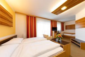 Llit o llits en una habitació de Der Trattner - Hotel Trattnerhof & Hotel Schöcklblick