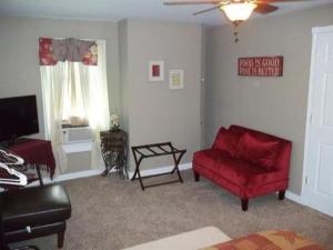 Walden的住宿－Tin Brook Bed & Breakfast，客厅配有红色沙发和红色椅子