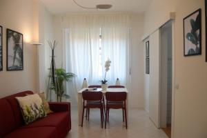 een woonkamer met een tafel en een rode bank bij ALTIDO Lovely Apt for 4 next to bus and metro station in Milaan