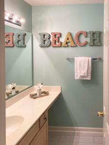 bagno con lavandino e specchio con la spiaggia di parole di Golf and Beach Retreat - River Oaks Resort Amenities a Myrtle Beach