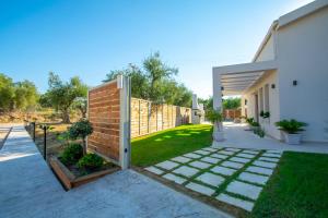 a backyard with a brick fence and a garden at Villa MANDI & JANI in Laganas