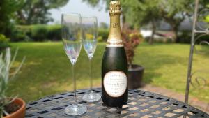 una bottiglia di champagne e due bicchieri di vino su un tavolo di No1 The Smithy a Tattenhall