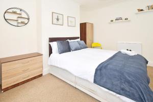 - une chambre avec un grand lit et une commode en bois dans l'établissement Townhouse @ Earle Street Crewe, à Crewe