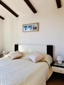 1 dormitorio blanco con 1 cama grande y 2 almohadas en Corinne Garden Residence, en Novigrad Istria