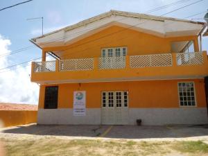 een geel gebouw met een balkon erboven bij Pousada Recanto da Enseada in Cabo de Santo Agostinho