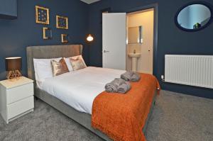 een slaapkamer met een groot bed met blauwe muren bij Townhouse PLUS @ London Road Stoke in Stoke on Trent