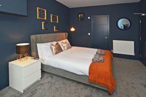 een slaapkamer met een bed met blauwe muren bij Townhouse PLUS @ London Road Stoke in Stoke on Trent