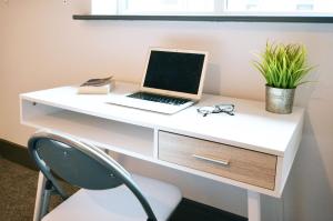 a white desk with a laptop computer on it at Townhouse PLUS @ London Road Stoke in Stoke on Trent