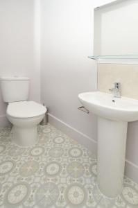 ein Badezimmer mit einem weißen WC und einem Waschbecken in der Unterkunft Townhouse PLUS @ London Road Stoke in Stoke on Trent