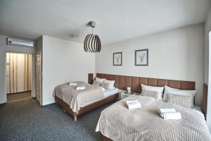 a bedroom with two beds and a pendant light at Apart Nova - pokoje gościnne in Szczyrk +9 photos