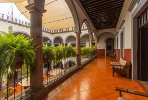 un corridoio con piante in vaso in un edificio di Hotel Hidalgo a Querétaro