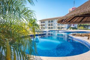 a pool with a palm tree and a building at Resort da Ilha in Sales