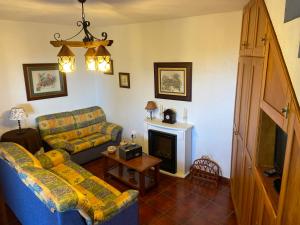 sala de estar con sofá y chimenea en CASAS RURALES TIO ANTONIO, en Las Rosas