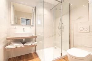 un bagno con doccia, lavandino e WC di Hotel Re'ser Stuff a Roeser
