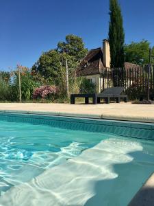 a swimming pool in front of a house at Chambres & Tables d'Hôtes L'Ostal de Pombonne in Bergerac