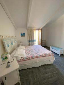 アルゲーロにあるAppartamento Via Sassariの白いベッドルーム(大型ベッド1台、テーブル付)