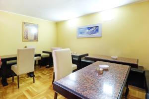 una sala da pranzo con tavoli, sedie e tavolo di Villa Tower Gardos a Belgrado