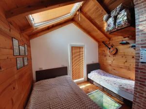 a bedroom in a log cabin with a bed and a window at Vacation Home Pliva in Šipovo