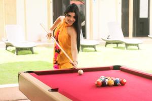 a woman playing a game of pool on a pool table at Casa Janaab Palenque in Palenque