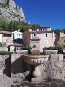 une fontaine en pierre au milieu d'une ville dans l'établissement Studio Appart Verdon, à Allemagne-en-Provence