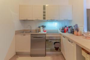 a kitchen with white cabinets and a stainless steel dishwasher at CASA CARLOTTA Tranquillità con Vista Mare in Camogli