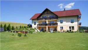 una casa grande con un campo verde delante de ella en Pension Kalista, en Klatovy