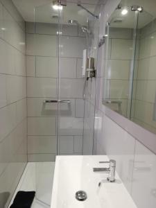 a white bathroom with a sink and a shower at Sea Breeze in Freshwater