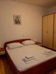 1 dormitorio con 1 cama con toallas en Apartments Čepo, en Makarska
