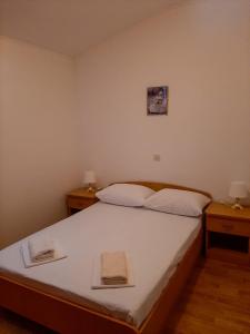 1 dormitorio con 1 cama grande y 2 mesitas de noche en Apartments Čepo, en Makarska
