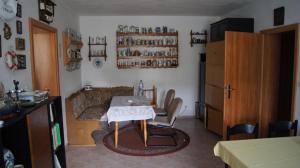 a living room with a table and a kitchen at Pension Kalista in Klatovy