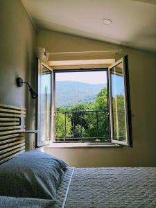 a bedroom with a large window with a view at Casa vacanze Acero rosso in Massa Martana