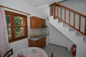 a kitchen with a table and a sink and stairs at Charoula in Platanias